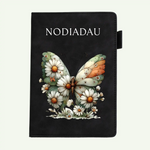 A black notebook with a butterfly and daisy illustration on the cover, featuring the word 'NOTEBOOK' in white text at the top, shown against a light off-white background.