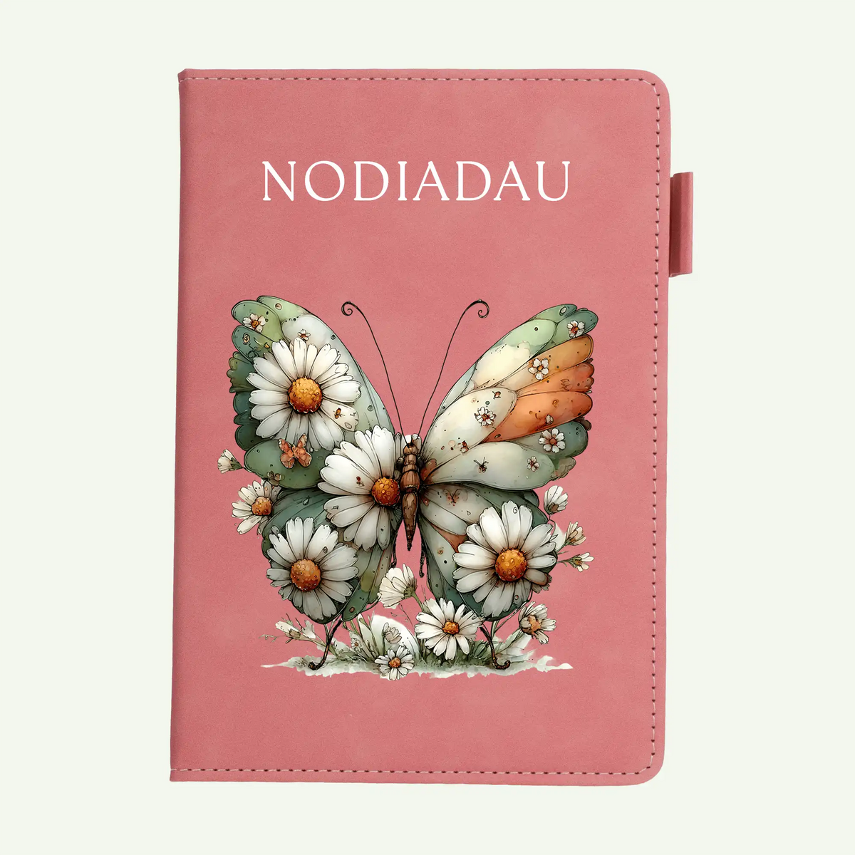 A pink notebook with a butterfly and daisy illustration on the cover, shown against a light off-white background.