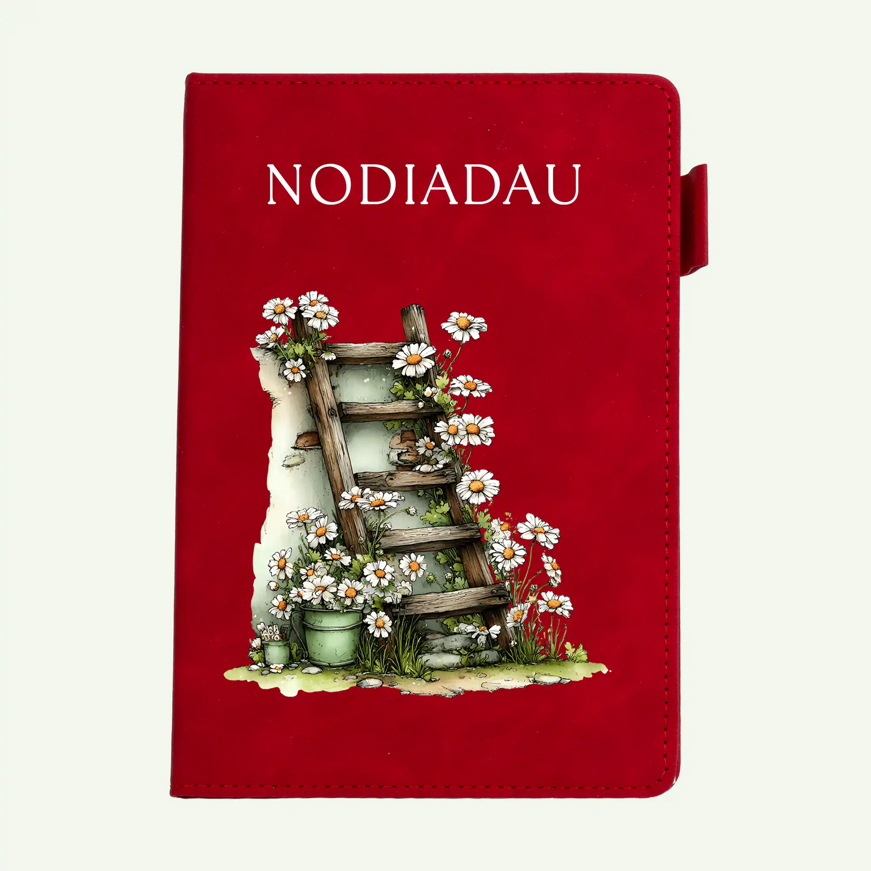 A red notebook or journal cover featuring the word 'NODIADAU' in white at the top and an illustration of a wooden ladder draped with white daisies and green foliage near the bottom center, shown on a plain light background.