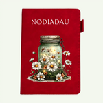 A red hardcover journal or notebook featuring the word 'NODIADAU' in white serif text at the top and an illustration of a glass jar filled with glowing light, surrounded by white daisies and small orange flowers on the front cover.
